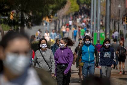 Familias caminan por un bulevar en Barcelona, España, el domingo 26 de abril de 2020, mientras continúa el bloqueo para combatir la propagación del coronavirus