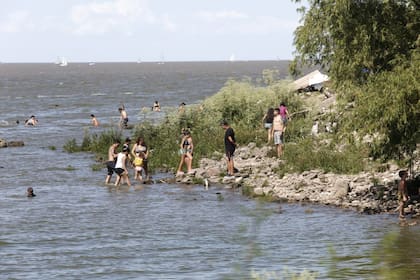 Familias enteras se acercan al Río de la Plata a refrescarse