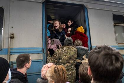 Las familias suben a un tren que se dirige al oeste hacia Lviv en la estación principal de trenes de Kiev, el 4 de marzo de 2022