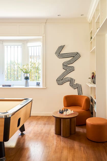 Fanáticos del ajedrez, se lo enseñaron también a sus hijos. Sillón, mesa y obra de la pared son diseños de Sol.