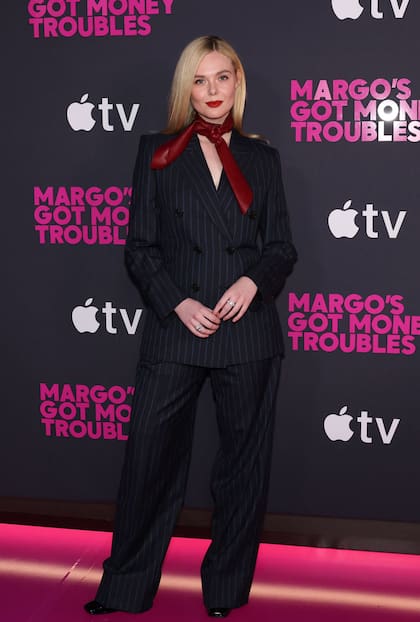 Fanning, a su vez, optó por un traje de raya diplomática en color gris oscuro, compuesto por un saco entallado y pantalones de corte recto