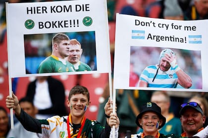 Fans hold placards with portraits of rugby players, one reading "here come the boks!" (L) prior to the start of the Rugby Championship final-round match between South Africa and Argentina at Ellis Park in Johannesburg on July 29, 2023. (Photo by WIKUS DE WET / AFP)�