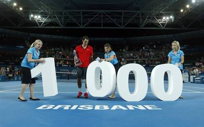 Federer, con el trofeo de Brisbane, dispuesto a posar para los fotógrafos con el trofeo y número de sus triunfos ATP.