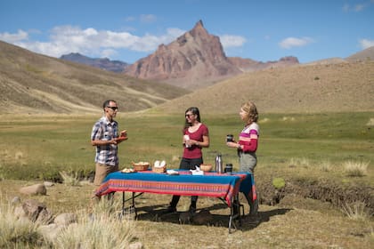 Federico Djeordjian, de Chelenco Tours, y una mesa montada para un alto en el camino del Zeballos, en Cerro Colorado.