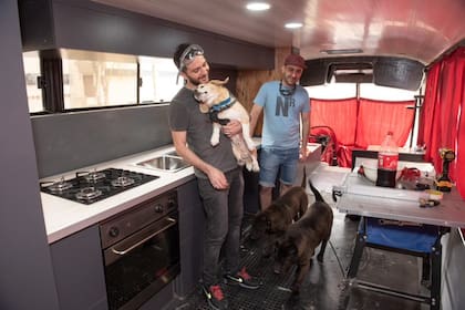 Federico (izq.)compró un colectivo de media distancia y lo adaptó para viajar al sur con sus perros Safira y Tupac