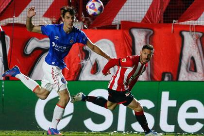Federico Redondo, hijo de Fernando, despeja ante Pablo Piatti, durante el triunfo de Argentinos Juniors contra Estudiantes.