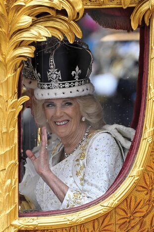 Feliz, Camilla saluda a la multitud. Lleva puestos la corona de María de Teck, el fabuloso collar de la reina Victoria compuesto por 25 brillantes y el gran diamante Lahore, de 22,48 quilates que eligió para el histórico día.