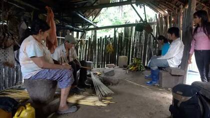 Fermin le enseña a los más jóvenes sobre el cuidado con el cáñamo con el que se hacen las flechas