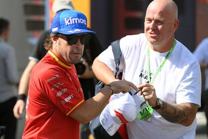 Fernando Alonso firma autógrafos en la calle de boxes del circuito de Montmeló; el asturiano escuchará propuestas de otros equipos, mientras negocia un nuevo contrato con Alpine