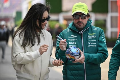 Fernando Alonso firma una réplica en miniatura de su casco antes del GP de China de esta temporada: a sus 44 años, la relación con sus fan se mantiene intacta