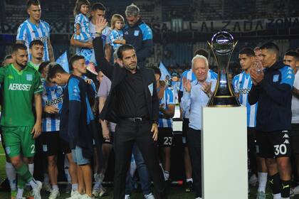 Fernando Gago y la chaqueta que le entrego Racing, al estilo del Master de Augusta de golf; la tribuna lo vivió con tibieza por el desencanto del empate con Belgrano