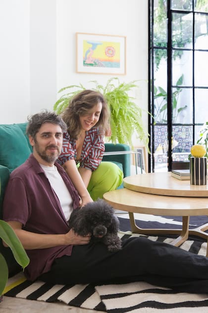 Fernando, músico y Elisa, DJ posan con su caniche. Entre los dos, encararon más de un año de obra para poner a punto su PH en Belgrano R.