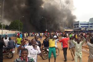 Festejos por el golpe de Estado en Níger, con la sede del gobierno ardiendo de fondo