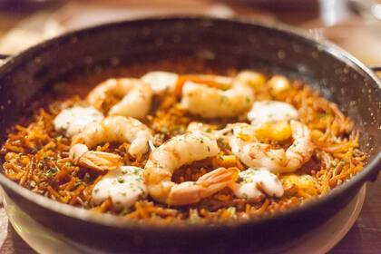 Fideua con tomate sofrito con oliva, calamares, pimentón y ajo.