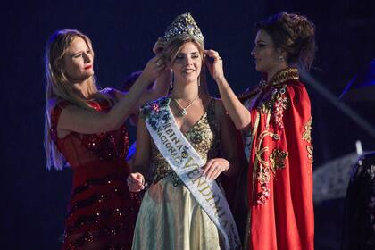La Reina saliente, Julieta Lagos, y Jesica Tolin, coronan a la nueva Reina Nacional de la Vendimia, María Laura Micames.