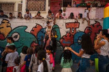 Filas de chicos en la comunidad de El Cementerio, Caracas, para subir al inflable colocado por las pandillas