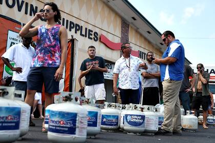 Filas de gente en la tienda de U-Haul para llenar garrafas de propano antes de la posible llegada del huracán Dorian, en Boynton Beach, Florida