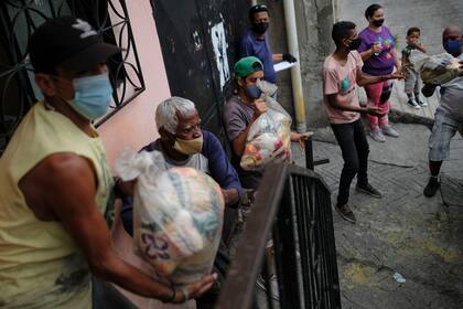 filas para obtener una bolsa de comida en los CLAP (AP Photo/Matias Delacroix, File)