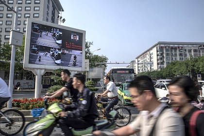 En un cruce de calles de la ciudad de Xiangyang, una pantalla exhibe a los conductores imprudentes, localizados con tecnología de identificación facial