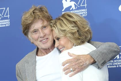 FILE - Actors Robert Redford and Jane Fonda hug as they pose for photographers at the photo call of the film "Our Souls at Night" during the 74th edition of the Venice Film Festival in Venice, Italy, on Sept. 1, 2017. (Photo by Joel Ryan/Invision/AP, File)