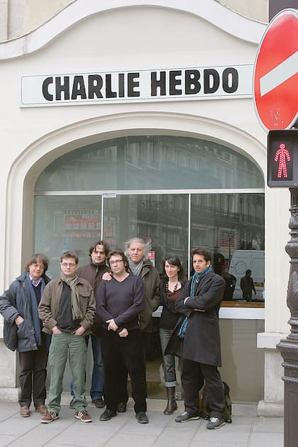 (FILES)-- A file photo taken on March 15, 2006 shows members of the French satirical newspaper Charlie Hebdo, including cartoonists Cabu (L), Charb (2nd L), Tignous (4th L) and Honore (5th L) posing in front of the then headquarters of the weekly in Paris. At least 12 people were killed, including cartoonists Charb, Wolinksi, Cabu and Tignous, when gunmen armed with Kalashnikovs and a rocket-launcher opened fire in the Paris offices of French satirical weekly Charlie Hebdo on January 7, 2015. AFP PHOTO / JOEL SAGET