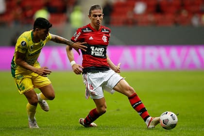 Filipe Luis mide el pase ante la marca de Lautaro Escalante; en Brasilia y ante 18 mil espectadores, Flamengo demostró contundencia para vapulear en el resultado a Defensa y Justicia