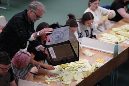 Fiscales de mesa vacían una urna durante el escrutinio en un centro de votación británico