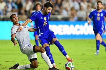Flaco López, en acción en el equipo nacional; detrás, Lionel Messi