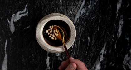 Flan y lágrimas de coliflor (esferificado) con un fondo de rabo centrifugado y aceite de almendra prensado