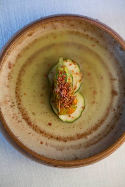 Flor de zucchini rellena de trucha, con polvo de jamón serrano sobre pepino armenio, uno de los pasos del menú de
Azafrán en Bodega Vistalba.