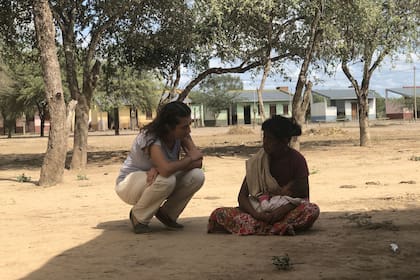 Florencia Ruiz, directora de Pata Pila en la zona de Santa Victoria Este, invita a una madre a que se acerque a los puestos de atención