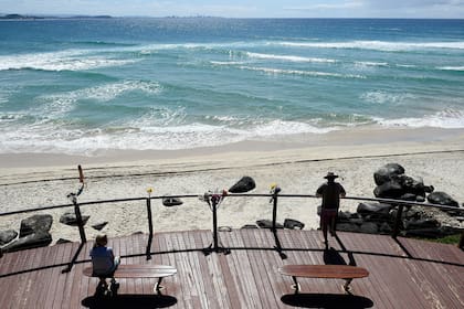Flores atadas a un pasamanos en un monumento a un surfista que murió después de ser mordido por un tiburón en Greenmount Beach en Coolangatta, Australia, en septiembre