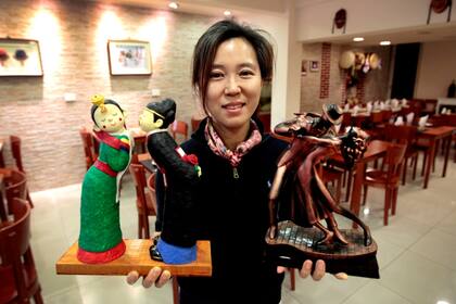 Flores: Hye Hyun Son, o Alexandra, y las efigies de dos parejas en bailes típicos: una, coreana; la otra, argentina