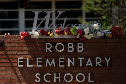 Flores son colocadas alrededor de un letrero de bienvenida fuera de la Escuela Primaria Robb en Uvalde, Texas, el miércoles 25 de mayo de 2022.