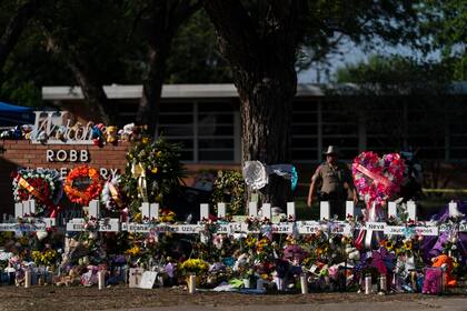  Flores y velas yacen alrededor de cruces el 28 de mayo de 2022 en una ofrenda instalada frente a la Escuela Primaria Robb, en Uvalde, Texas (AP Foto/Jae C. Hong, archivo)