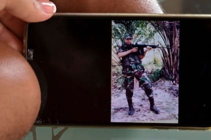 Florián y su esposa Angie muestran una foto de él cuando era soldado