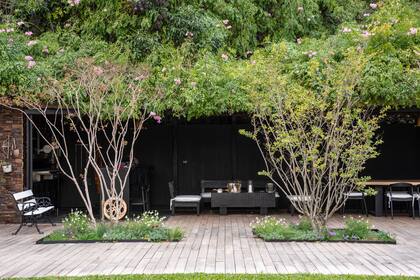 Formas geométricas caladas en el deck albergan unas lagerstroemias arbustivas con naselas, verbenas y salvias, que dan un marco vegetal y algo de reparo al quincho.