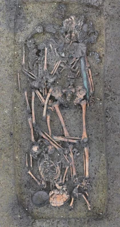 Fosa funeraria con la espada entre los huesos de las tres personas enterradas