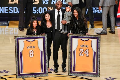 Kobe Bryant y su familia durante la ceremonia del retiro de los dos números que usó jugando en los Lakers