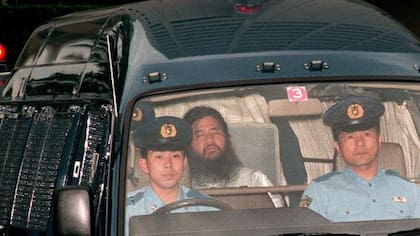 Foto de archivo del 16 de junio de 1995, que muestra al fundador del culto Aum Shinrikyo, Shoko Asahara (c), con nombre de nacimiento Chizuo Matsumoto, quien es escoltado por la policía