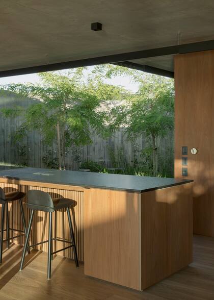 Las banquetas son en hierro negro, haciendo juego con la superficie oscura de la isla.