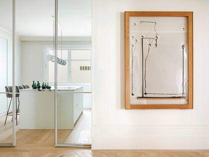 La entrada de la cocina tiene puertas de vidrio corredizas, que establecen un límite entre el parquet y el entablonado.