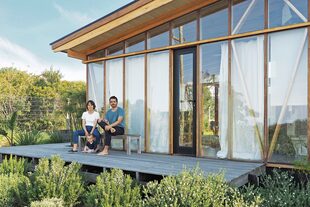 Delfina y Franco posan en su hogar hecho con estructura de multilaminado de eucalipto y vidrios dobles con cámara de aire.