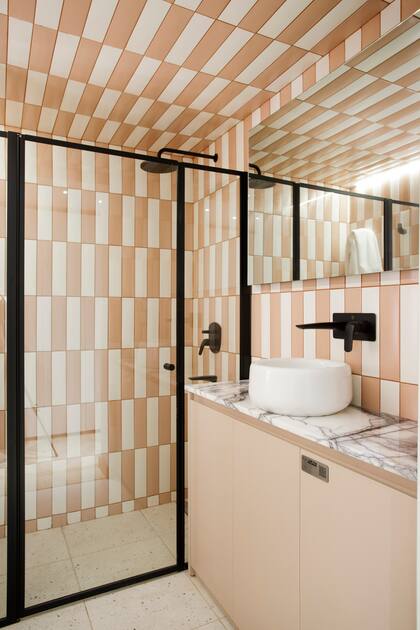 Piso 'Fides' color hueso, paredes y techo en cerámicos 'Ombre Lady Blush' y 'Fit White' (todo de San Lorenzo Design). Mesada de mármol 'Lillac' (De Stefano, por Mármoles Milán). Vanitory en melamina 'Himalaya' de Faplac ejecutada por Dwell. Bacha 'Milos' (Ferrum). Mampara y espejo (Shawer). Grifería 'Epuyén' (FV).