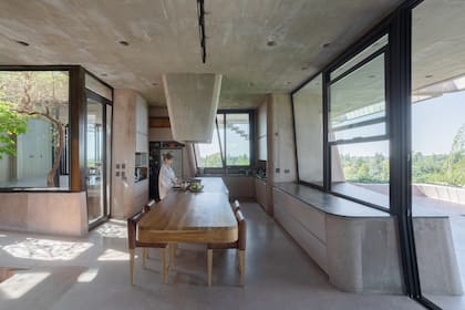 El comedor está frente a la cocina que mira hacia la inmensidad del paisaje. Para recibir y compartir, la isla se une con otra mesa de madera.