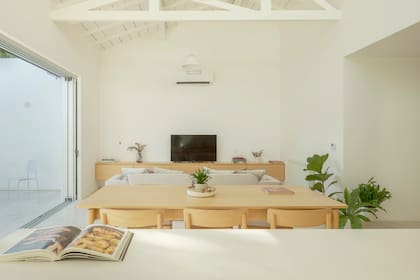 Más allá de la mesa del comedor, un sillón generoso para las horas de ocio.