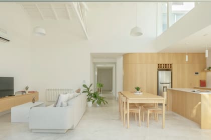 La curva que propone el mueble en guatambú es clave para suavizar la transición entre cocina, living y escalera.