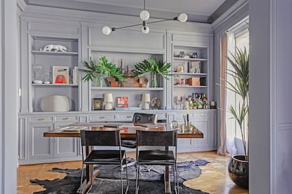 Alfombra de cuero de vaca (Grevy), mesa forrada en cuero (Eugenio Aguirre), sillas ‘Q’ (Cúmulo), lámpara (Astor Luces) y barco de madera (Salazar Casa) sobre uno de los estantes.