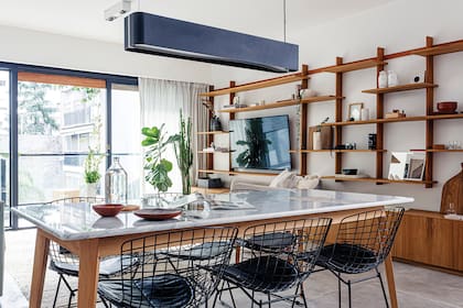 Mesa con tapa de mármol de Carrara y base de pino Brasil (Arq. Sofía Ledesma), sillas ‘Bertoia’, lámpara ‘Grisín’ (La Feliz).