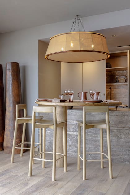 El gran imán de la zona social, la escultural isla curvilínea diseñada por CN está hecha en Travertino 'Silver' con terminación taponado mate (De Stefano) y fue ejecutada por Marmolería Casella.